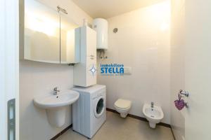a bathroom with a washing machine and a sink at Condominio Mimose in Eraclea Mare +17 photos