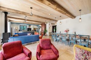 a living room with red chairs and a blue couch at Lou Papagai in Saint-Antonin