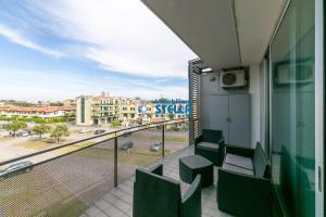 a balcony with chairs and a view of a street at Condominio Mimose in Eraclea Mare