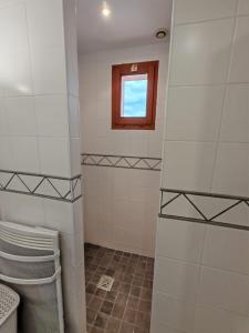 a bathroom with a window and a tiled shower at gite villa ardeche joyeuse piscine in Joyeuse +26 photos