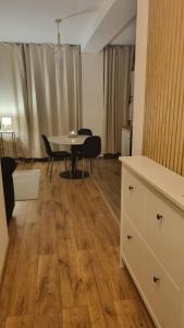 a living room with a table and a dining room at Scandinavian Studio Bucharest in Dudu