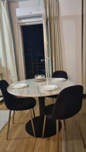 a dining room table with four chairs and a window at Scandinavian Studio Bucharest in Dudu