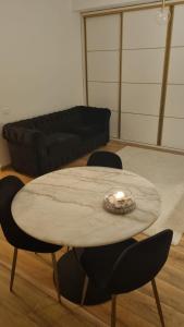 a living room with a table with chairs and a couch at Scandinavian Studio Bucharest in Dudu