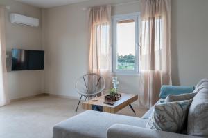a living room with a couch and a table and a window at Family Heritage Homes- Skiathos in Skiathos