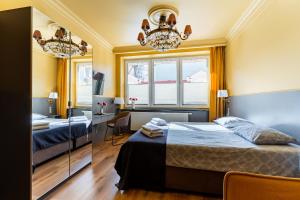 a bedroom with two beds and a desk and a chandelier at Gościniec in Sopot