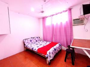 a small bedroom with a bed and a window at OYO 1214 Cherry Travellers Inn in San Jose de Buenavista