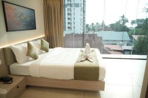 a bedroom with a bed and a large window at Hotel Calicut Beach-Silk Street in Kozhikode +52 photos