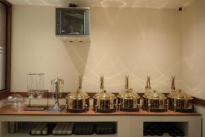 a group of silver drums on a shelf with a tv at Hotel Calicut Beach-Silk Street in Kozhikode