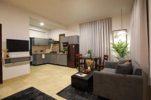 a living room with a couch and a kitchen at BedChambers Serviced Apartments, Sushant Lok in Gurgaon