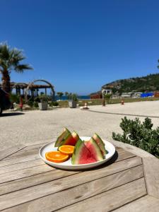 a plate of fruit on a wooden table at Alex & Sofi Hotel in Himare