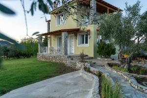 a yellow house with a walkway in front of it at Family Heritage Homes- Skiathos in Skiathos