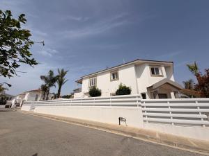 a white fence in front of a house at Villa Andy-350 m from the beach in Larnaca