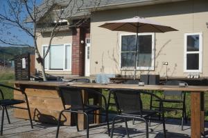 a large wooden table with chairs and an umbrella at Kaede Lakehouse Toya in Lake Toya