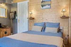 a bedroom with a blue bed with two pillows at Chambres d'Emilie - Table d'Hôte in Lau-Balagnas