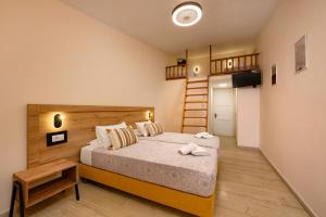 a small bedroom with a bed and a staircase at Siora Leni Hotel in Benitses
