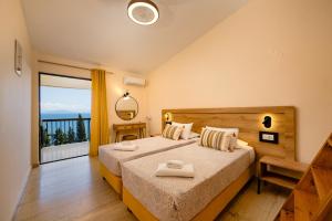a bedroom with a large bed and a large window at Siora Leni Hotel in Benitses