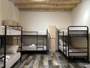 ein Zimmer mit drei Etagenbetten und einem Holzboden in der Unterkunft Hostel Vila H in Tirana