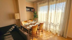 a dining room with a table with chairs and a window at Apartment Segura 2BD in Rojales