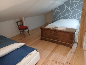 a small bedroom with a bed and a chair at Gite de Labarraque in Monbahus