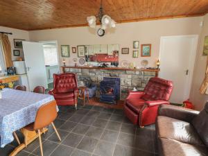 a living room with a table and chairs and a fireplace at Sweetbriar Lodge in Castlerea