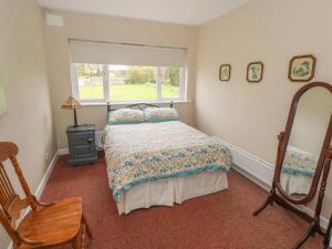 a bedroom with a bed and a window and a chair at Sweetbriar Lodge in Castlerea
