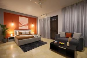 a bedroom with a bed and a couch at BedChambers Serviced Apartments, Sushant Lok in Gurgaon