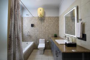 a bathroom with a tub and a toilet and a sink at BedChambers Serviced Apartments, Sushant Lok in Gurgaon +33 photos