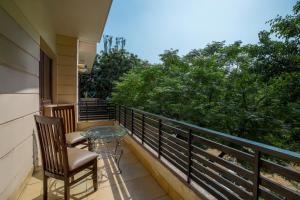 a balcony with a glass table and two chairs at BedChambers Serviced Apartments, Sushant Lok in Gurgaon