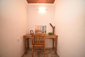 a desk in a room with a chair and a painting at The cliff boutique in Varkala