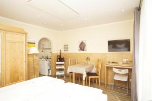 a room with a bed and a table and a kitchen at Bungalow Hanseatchen in Baabe