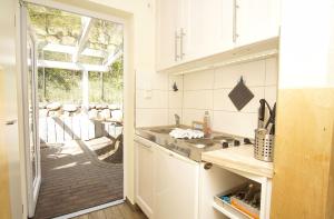 a kitchen with a sink and a door to a patio at Bungalow Hanseatchen in Baabe