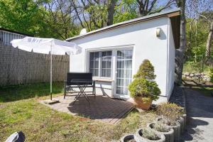 a chair and an umbrella in front of a tiny house at Bungalow Hanseatchen in Baabe