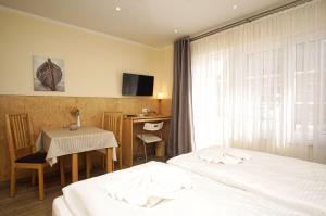 a hotel room with two beds and a desk at Bungalow Hanseatchen in Baabe