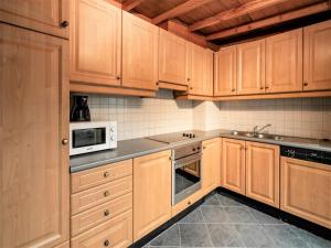 a kitchen with wooden cabinets and a sink and microwave at Deluxe Capital Street Stay for 12 in Antwerp