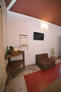 a living room with a couch and a tv on a wall at The cliff boutique in Varkala