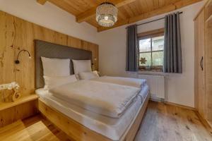 a bedroom with a large white bed in a room at Ferienwohnungen Holzferienhäuser Leithenwald in Zwiesel