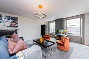 salon z niebieską kanapą i pomarańczowymi krzesłami w obiekcie One Capel Suites w Dublinie