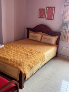 a bedroom with a large bed with a wooden headboard at Hotel Tuấn Anh in Vô Hối