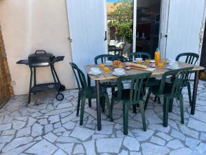 a table with chairs and a grill on a patio at Maison petit havre de paix in Palavas-les-Flots