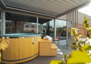 a hot tub on a patio with a table and a chair at MY HOTEL MALMEDY in Malmedy