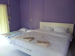 1 dormitorio con 2 camas con sábanas y almohadas blancas en Baan Phuean Koh Kood, en Ko Kood