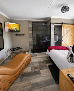 a bedroom with a large bed and a glass shower at Rudman's Private Love Nest in Boksburg
