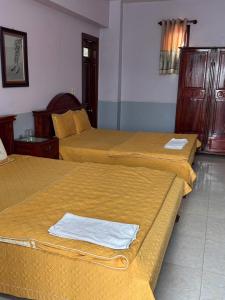 three beds in a hotel room with towels on them at Hotel Tuấn Anh in Vô Hối