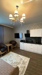 a living room with a couch and a chandelier at DiAmel in Petropavlovskaya Borshchagovka