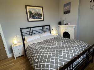 a bedroom with a bed with a black and white comforter at Swan Lodge in Swanage