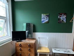 a room with a desk with a television and a chair at Swan Lodge in Swanage +8 photos