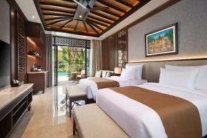 a hotel room with two beds and a television at MĀUA OLEA Ubud by Swiss-Belhotel in Ubud +39 photos