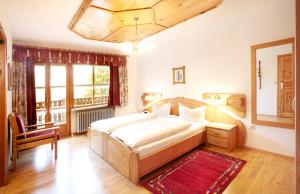 ein Schlafzimmer mit einem Bett, einem Stuhl und einem Fenster in der Unterkunft Gästehaus Apfelbacher in Spiegelau