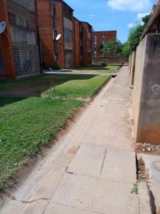 an empty sidewalk in front of a brick building at Apartment 8, 7373A, Mtedza Rd in Lusaka