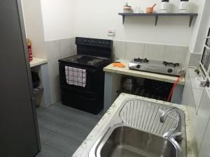 a small kitchen with a stove and a sink at Apartment 8, 7373A, Mtedza Rd in Lusaka
